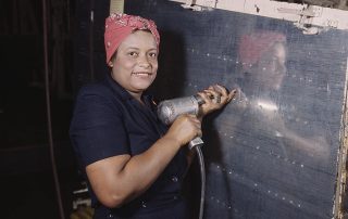 Operating a hand drill at Vultee-Nashville, a woman is working on a “Vengeance” dive bomber, Tennessee