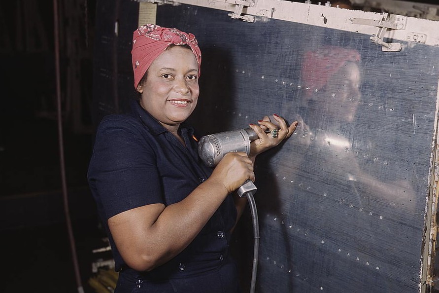 Operating a hand drill at Vultee-Nashville, a woman is working on a “Vengeance” dive bomber, Tennessee
